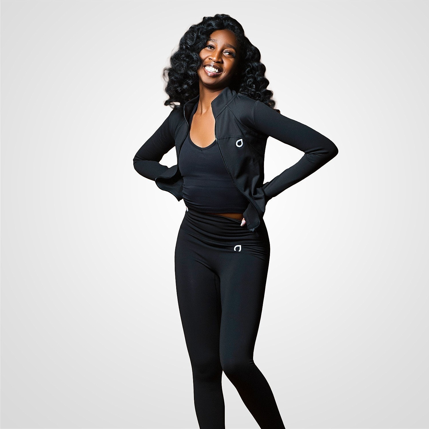 smiling model wearing unzipping dotado apparel evolved yoga set